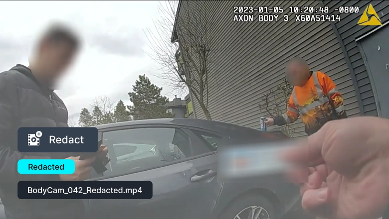 Bodycam scene: an officer in an orange safety vest interacts with a person near a gray car; another person is blurred in the foreground.