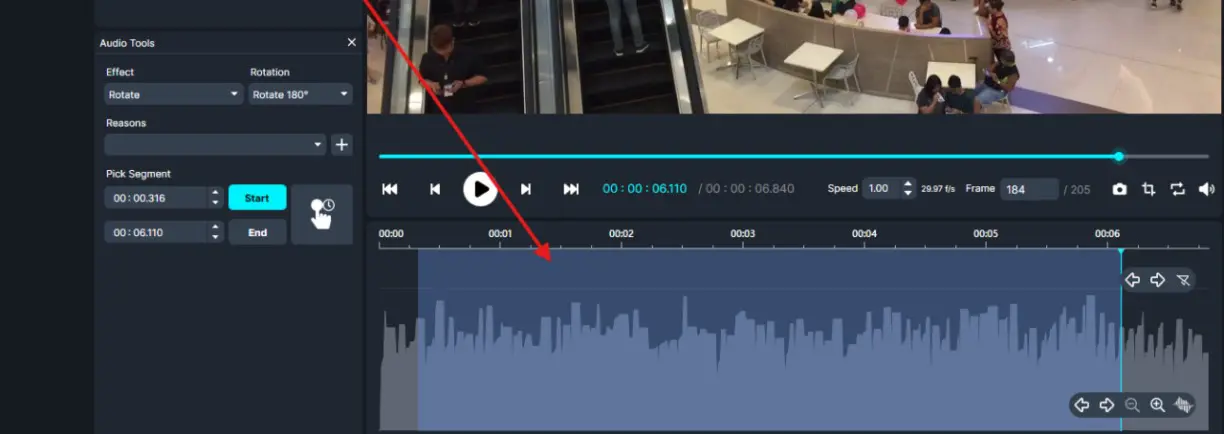 Video editing interface with video preview, playback controls, and a large audio waveform in the timeline section, highlighted by a red arrow mark of a selected region.