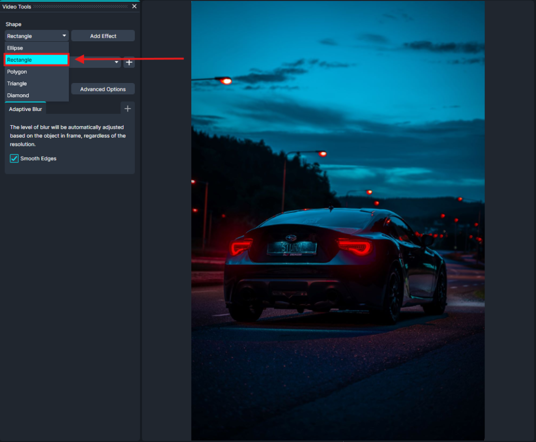 rectangle-cg | CaseGuard Rear view of a dark sports car driving down a city street at dusk, red taillights glowing.