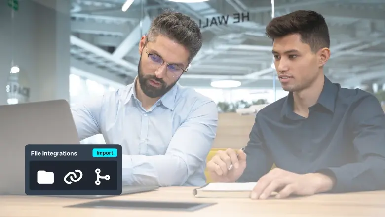 Two men collaborate at a desk with a laptop; a software panel labeled File Integrations Import sits on the screen in the foreground.